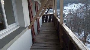 A wooden staircase leading to a balcony with a view of a snowy landscape. - CHALET ROMANE, SLEEPS 6, LAKE VIEW, AIR-CONDITIONED, BALCONY, MOTORCYCLE ROOM, GERARDMER (Gérardmer)