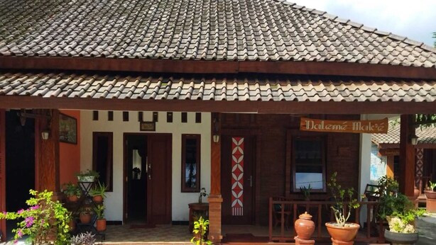Un bâtiment traditionnel avec un toit en tuiles et une enseigne indiquant « Dalem Mangkuto ».