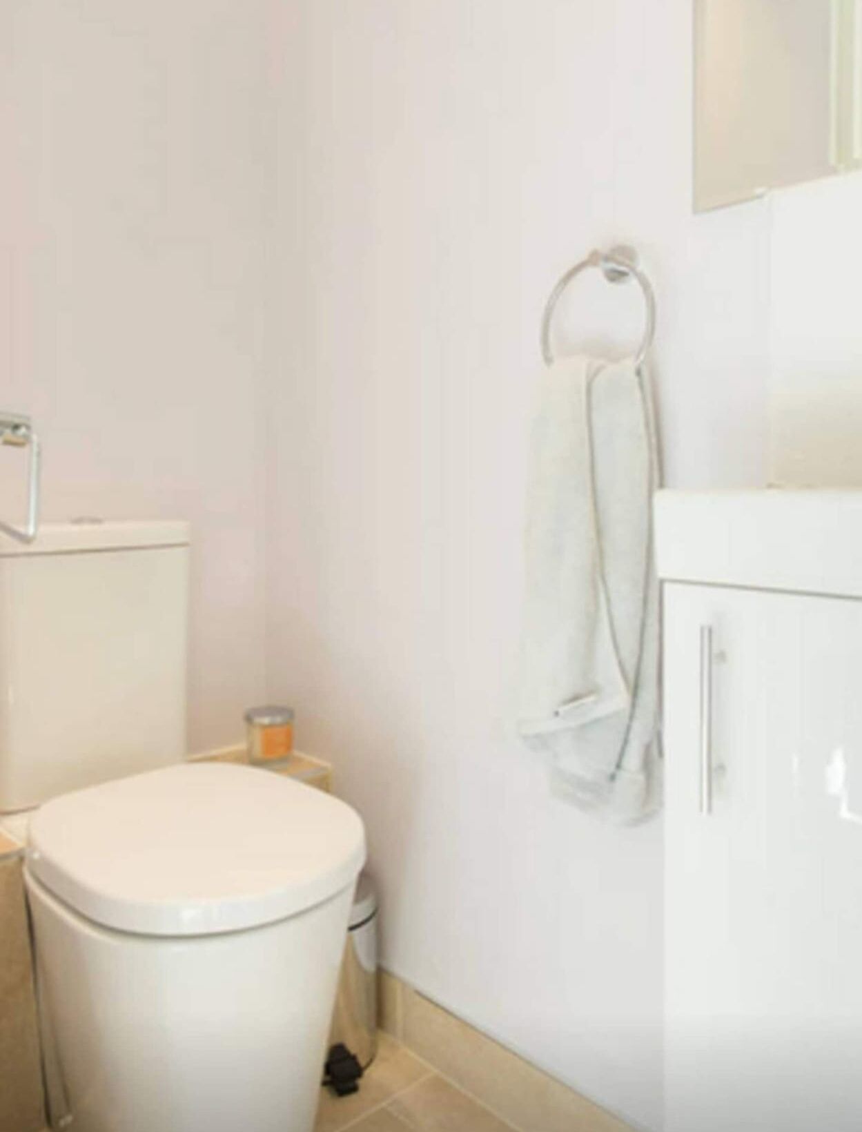 Ein Badezimmer mit Toilette, Waschbecken und einem Schrank.