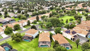 A residential area with houses, green lawns, and a swimming pool. - Windsor Hills! Free Pool Heat/BBQ/Waterpark. Game Room w/Theater, Themed Rooms. (Kissimmee)