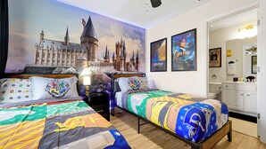 A bedroom with two beds, a large Hogwarts-themed mural on the wall, and a Harry Potter poster. - Windsor Hills! Free Pool Heat/BBQ/Waterpark. Game Room w/Theater, Themed Rooms. (Kissimmee)