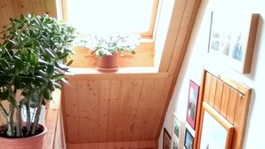 A narrow staircase with wooden steps, a potted plant on the landing, and framed pictures on the walls. - Vacation apartment in a quiet location for 2 people (non-smoking property) (Born)
