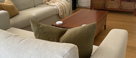 Ein Wohnzimmer mit einer Couch, einem Couchtisch und einem Fernseher auf einem Schrank.