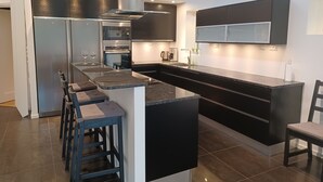 A modern kitchen with a central island, built-in appliances, and a sleek design.