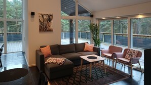 A spacious living room with a sectional sofa, a small coffee table, and a potted plant.