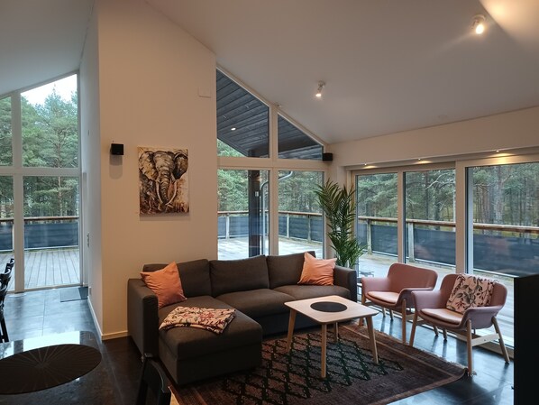 A spacious living room with a sectional sofa, a small coffee table, and a potted plant.