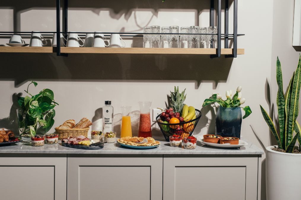 A kitchen counter with various food items and a fruit basket.