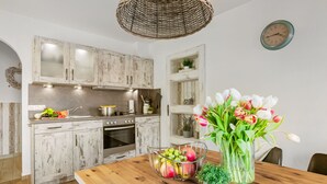 Eine Küche mit rustikalen Holzschränken, einem Holzesstisch und einem Blumenstrauß.