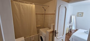 Bañera con ducha, secador de pelo, toallas, papel higiénico