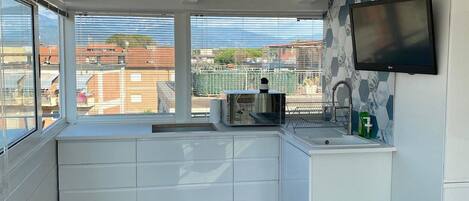 A compact kitchen with a window, a built-in microwave, and a sink.