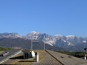 Una terraza con antenas parabólicas y una turbina eólica, con vistas a un paisaje montañoso.