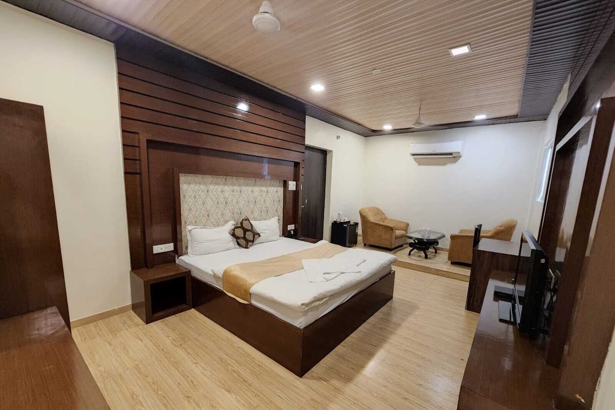 Une chambre d’hôtel moderne équipée d’un grand lit, d’un bureau, d’une chaise et d’une télévision.