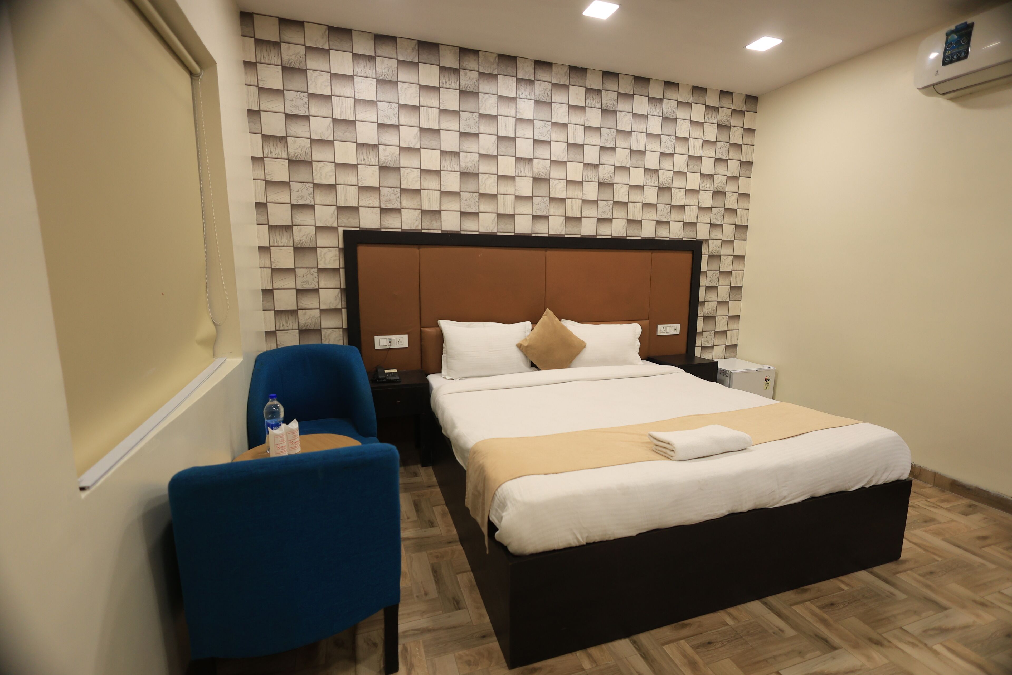 Ein Hotelzimmer mit Bett, Schreibtisch, Stuhl und einer Wand mit Schachbrettmuster.
