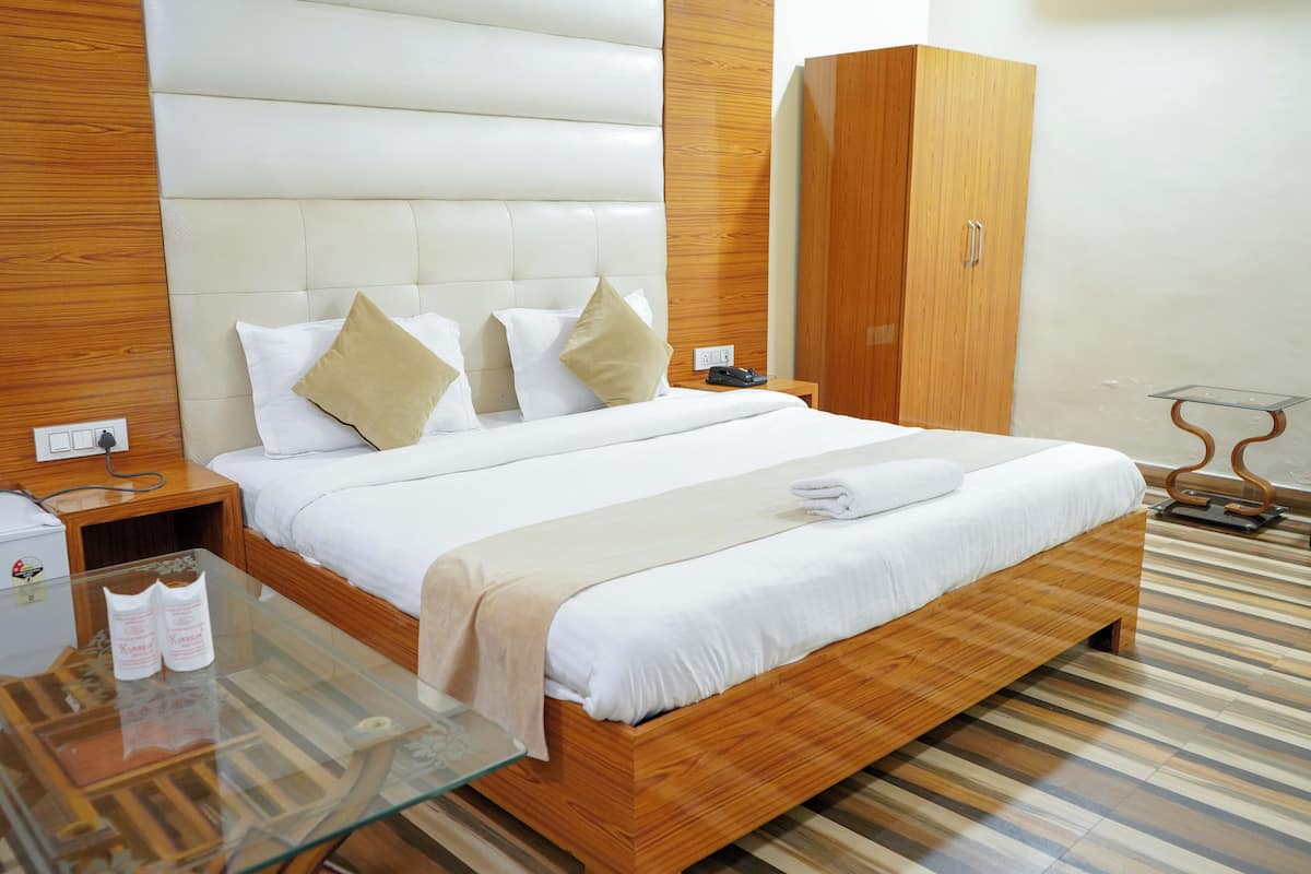 Une chambre d’hôtel moderne avec un cadre de lit en bois, une table basse en verre, une armoire en bois et un sol à rayures.