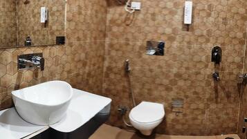 A bathroom with a hexagonal tile pattern, a white sink, a toilet, and a shower area.