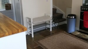 A kitchen with a wooden countertop, a white bench, a clock, a radiator, and a stove. - Stunning cosy cottage! Close to Haworth and amenities (keighley)