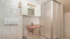 Un bagno con lavandino, specchio e doccia.