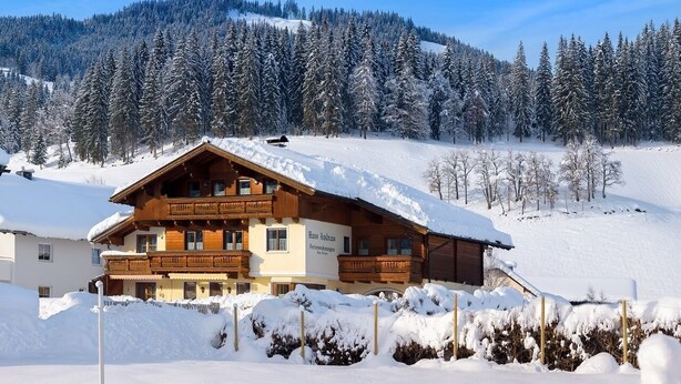 A wooden chalet with a balcony, surrounded by snow-covered trees and a mountain in the background. - Cozy Studio #5 - 5 mins to ski lift (Flachau)