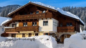 A traditional wooden chalet with a balcony, surrounded by snow and mountains. - Cozy Studio #5 - 5 mins to ski lift (Flachau)