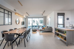 Relax in this inviting space with a central dining area, comfortable sofa, and large window offering a view of the outdoors.