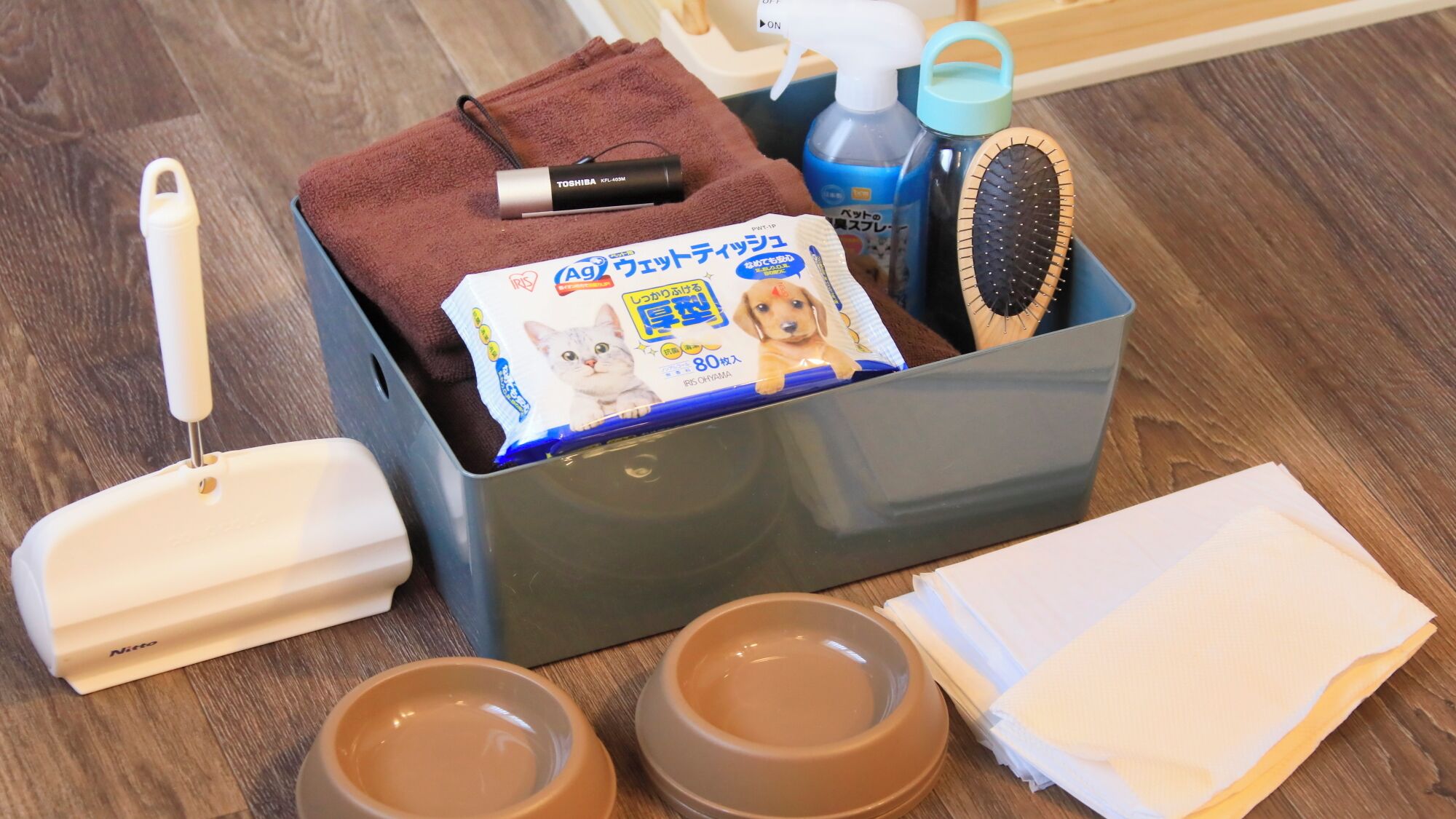Ein Set zur Tierpflege mit Zahnbürste, Handtuch, Flasche, Bürste und Näpfen.