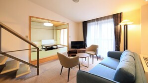 A hotel room with a sofa, chairs, a TV, a small table, and a staircase. - Yutorelo Garden Kitakaruizawa (Tsumagoi)