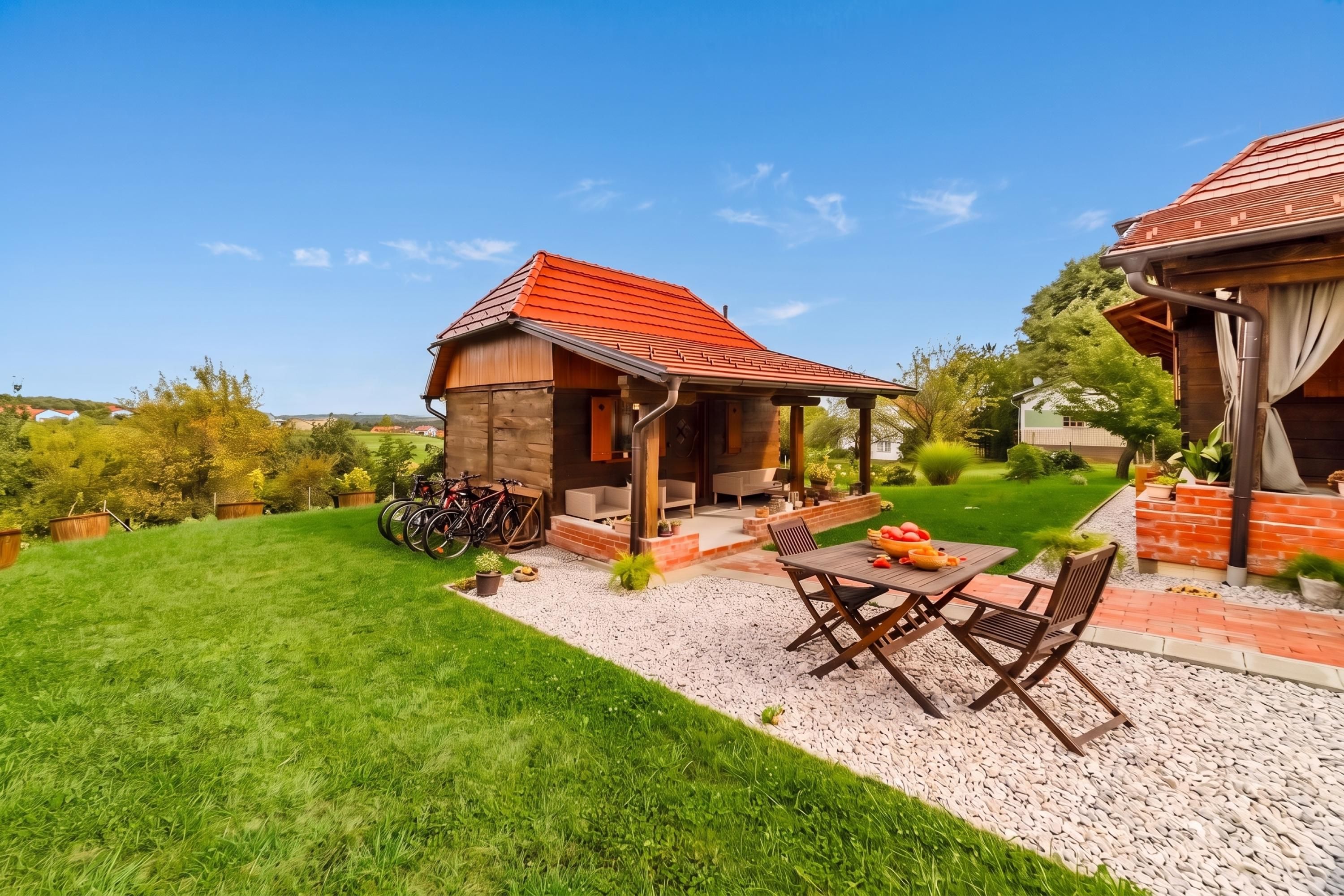 Una casa de madera con techo rojo, un patio con mobiliario exterior y un césped bien cuidado.