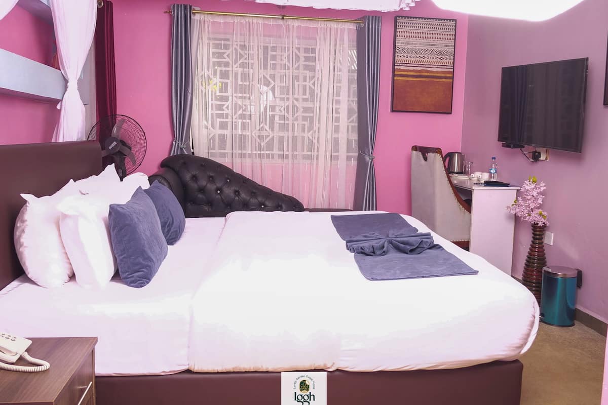 Una habitación de hotel con cama, mesita de noche y escritorio con silla.