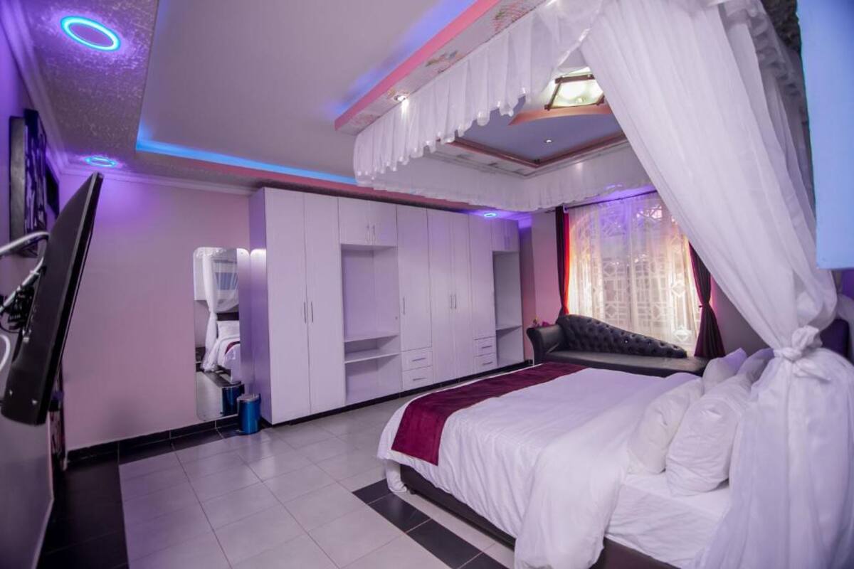 Un dormitorio con cama, armario y televisor.