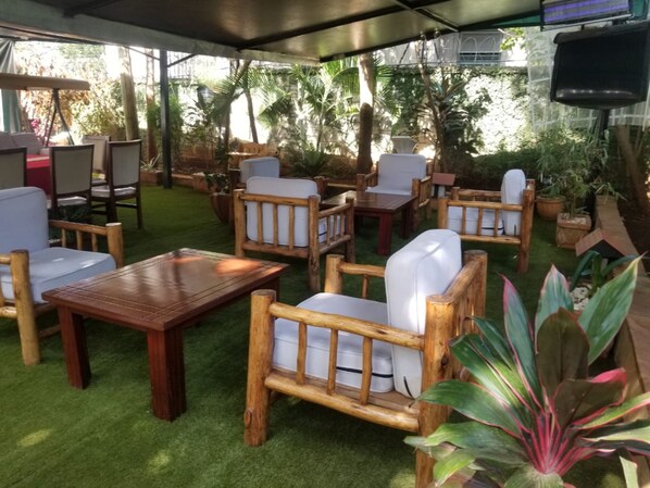 An outdoor patio area with wooden furniture and artificial grass.