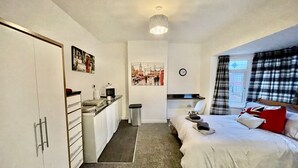 A bedroom with a bed, a desk, a chair, a clock, and a window with curtains. - 3 Bed House - Sleeps 5 - Wifi, Parking (Darlington)