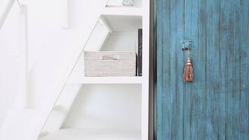 Una escalera con paredes blancas y una puerta azul.