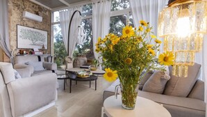 Una sala de estar acogedora con un sofá, una mesita de centro y un jarrón de flores amarillas.