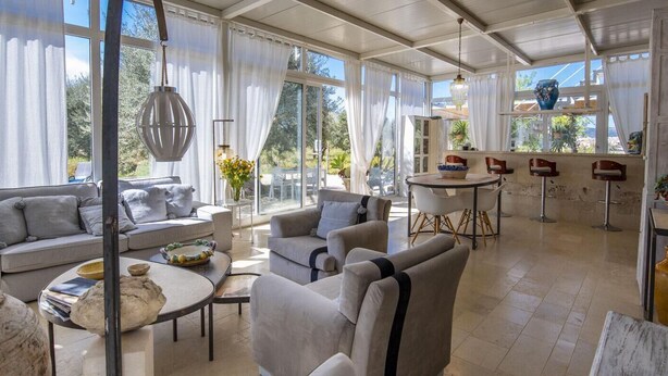 Amplia sala de estar con sofá, sillones y mesa de comedor.