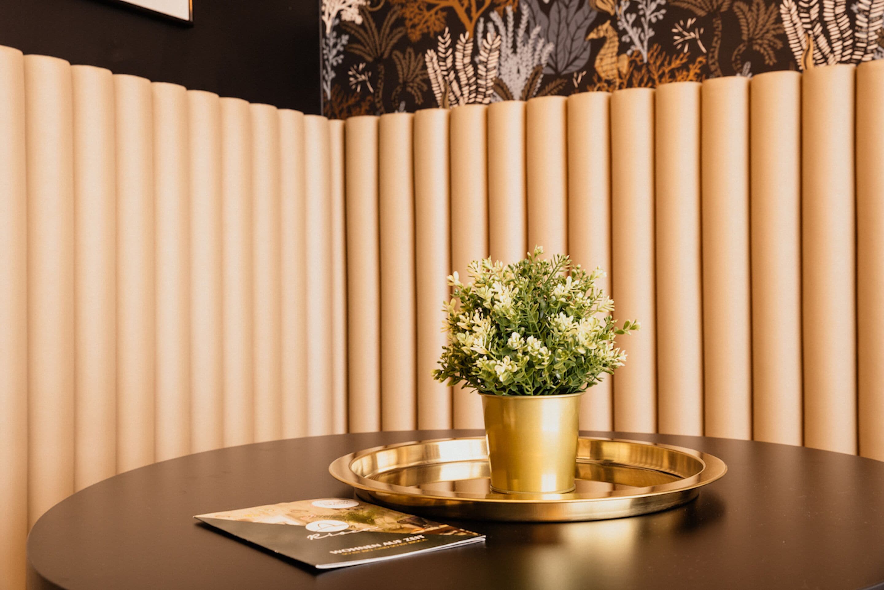 A round table with a gold tray and a potted plant.