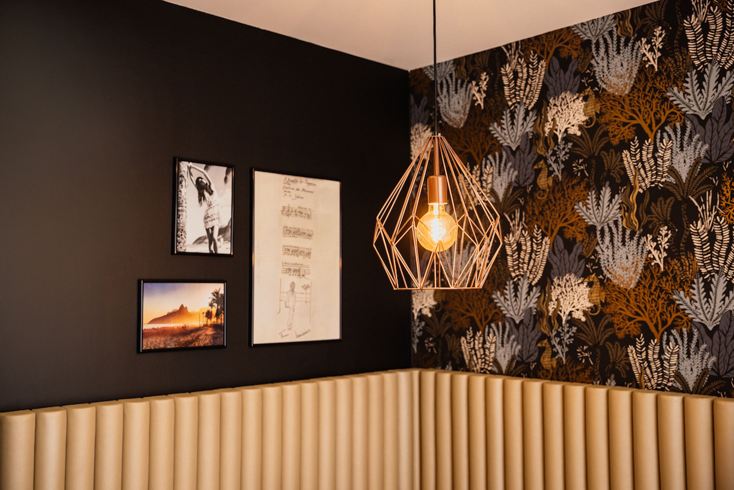 A room with a black wall, a patterned wallpaper, and a geometric light fixture.