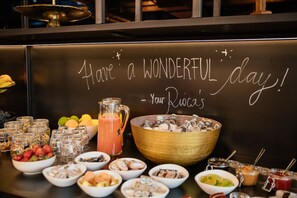 A breakfast buffet with a variety of food items and a large bowl of ice.