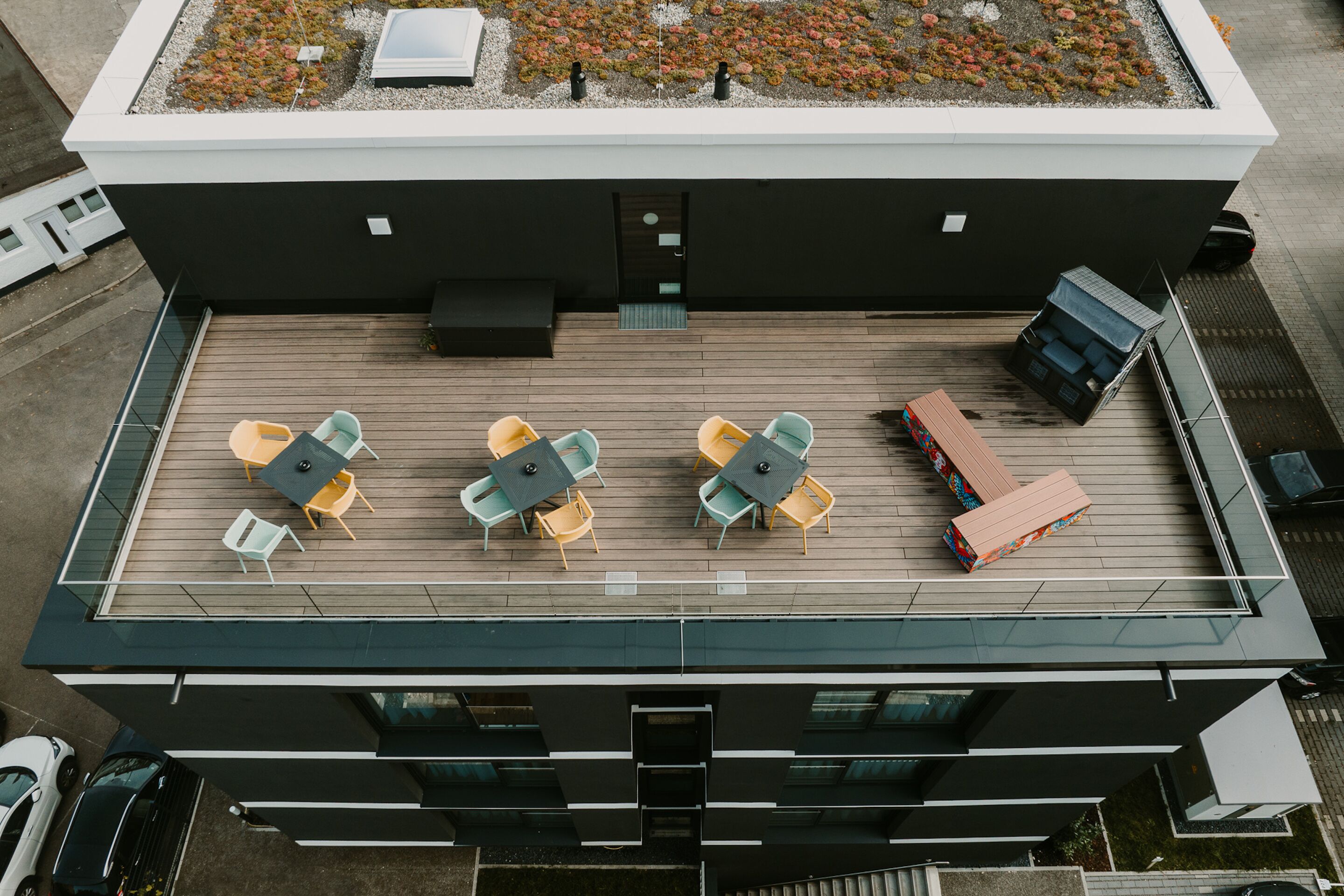 A rooftop terrace with outdoor seating and a modern building design.