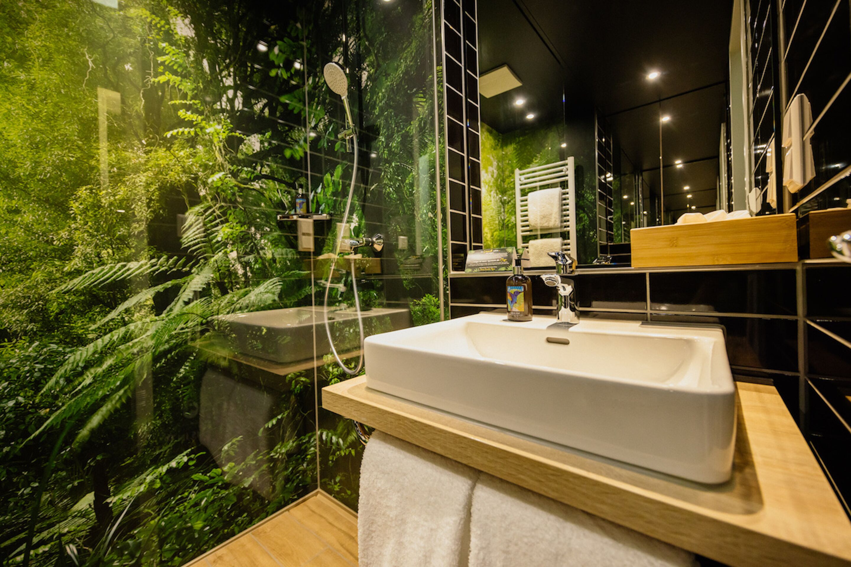 A modern bathroom with a large sink, a mirror, and a shower.