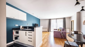 A modern apartment with a kitchen, dining area, and living room. - Central apart 1 room near beaches with parking (Barcelona)