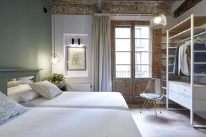 Une chambre avec deux lits, un radiateur, un tableau encadré, une chaise et une armoire.