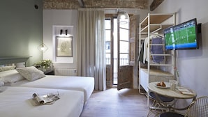 Une chambre d’hôtel avec un lit, un bureau et une chaise, une télévision et une vue sur l’extérieur.