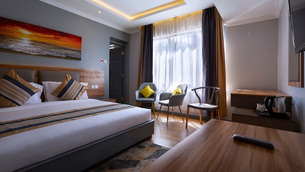 Ett modernt hotellrum med en stor säng, ett skrivbord och en stol.