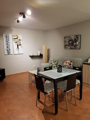 A dining area with a table, chairs, and artwork on the walls.