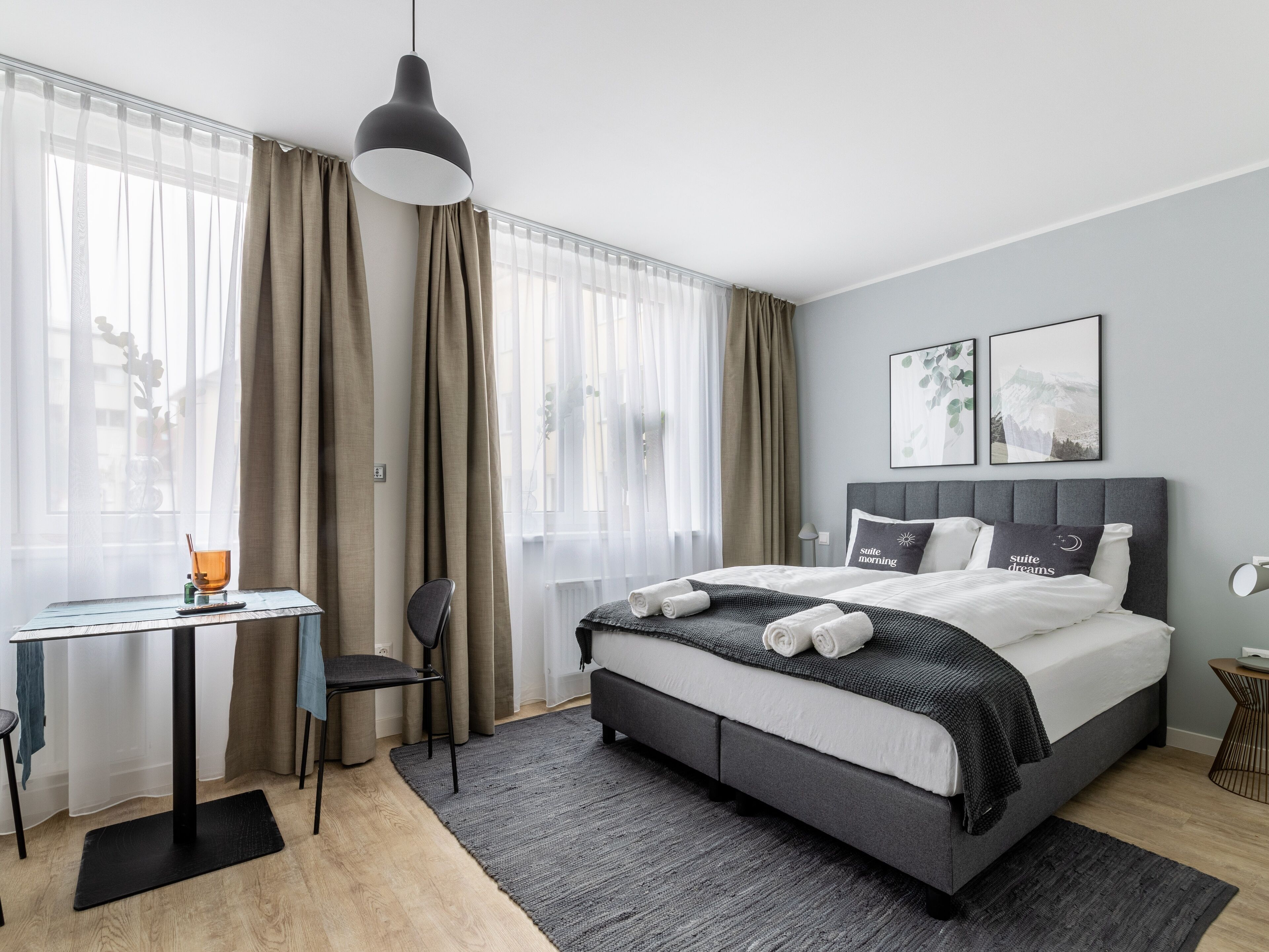 Una habitación de hotel moderna con una cama, un escritorio y una silla.