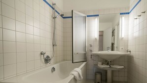 Kylpyhuone, jossa on kylpyamme, pesuallas, peili ja wc.