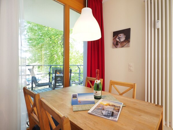 Une table en bois avec une bouteille de champagne, un magazine et une brochure.