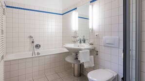A modern bathroom with a bathtub, sink, and toilet.