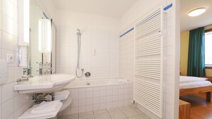 Ein Badezimmer mit Waschbecken, Spiegel, Toilette, Dusche und Badewanne.