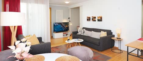 A modern living room with a sofa, a coffee table, and a TV.